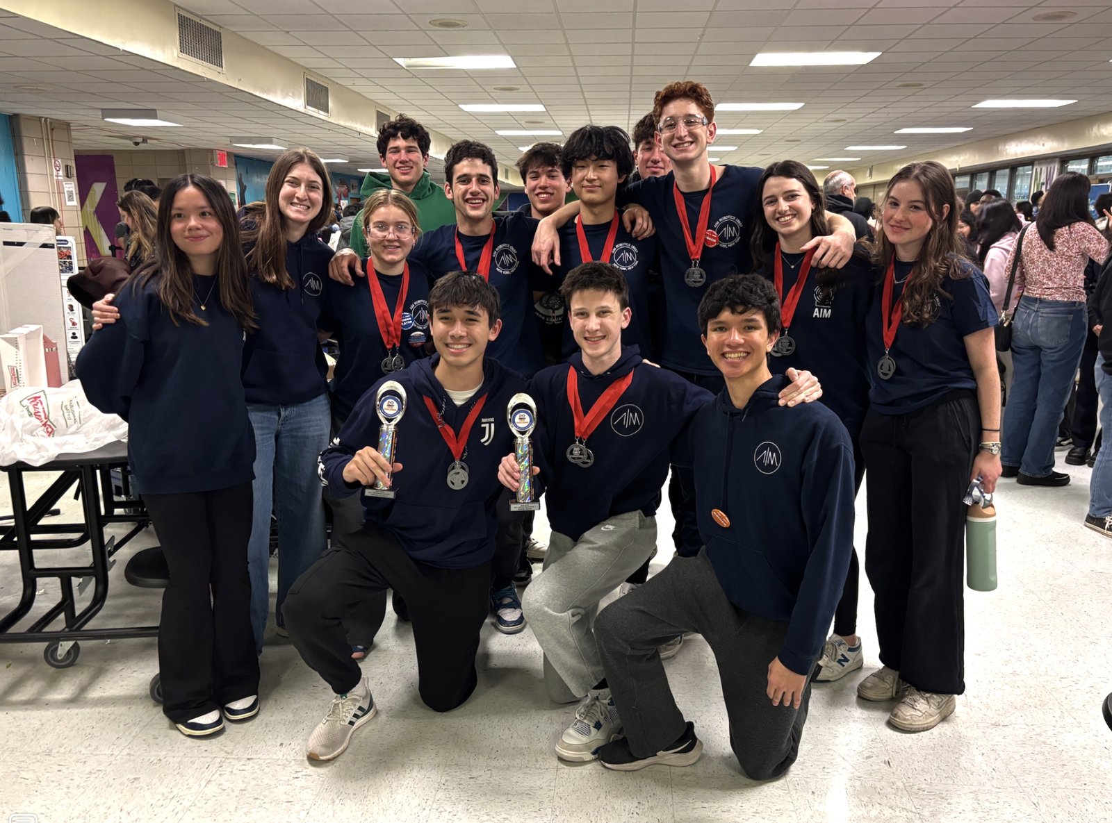 FIRST Tech Challenge team celebrating with medals and trophies at an NYC competition